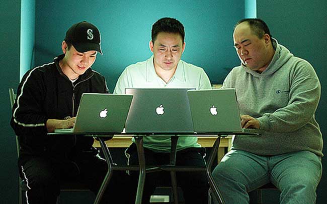 Geeks in front of their apple laptops