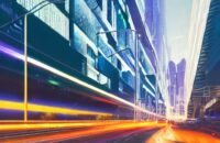 A futuristic twilight metropolis where glowing fiber optic cables weave through skyscrapers, symbolizing AI as the essential infrastructure powering modern urban life.