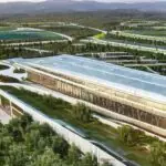 A photorealistic wide shot of a modern technology campus under construction in rural West Virginia, featuring sleek glass buildings surrounded by green fields with cinematic golden hour lighting.