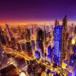A solitary figure stands on a rooftop overlooking a futuristic metropolis at twilight, where towering skyscrapers pulse with glowing blue and violet fiber-optic cables, symbolizing individual autonomy within massive digital infrastructure.