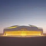 A futuristic datacentre in the Arabian desert at sunset, showcasing resilient, state-led infrastructure with sleek white architecture and glowing blue servers amidst golden sand dunes.