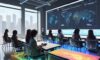 Diverse students collaborate around a holographic table displaying personalized learning pathways, illustrating modern, tech-enhanced education and teamwork.