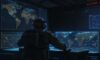 A cinematic shot of a high-tech military command center where soldiers in tactical gear monitor orbital maps and satellite data on glowing screens with a holographic projection of a satellite constellation.
